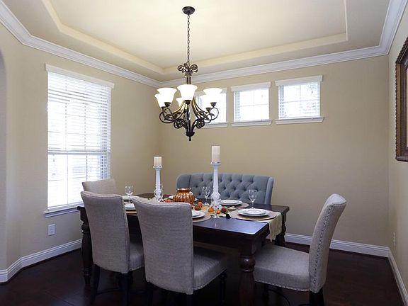 The formal dining room has an abundance of windows, enhanced ceiling, and neutral paint.