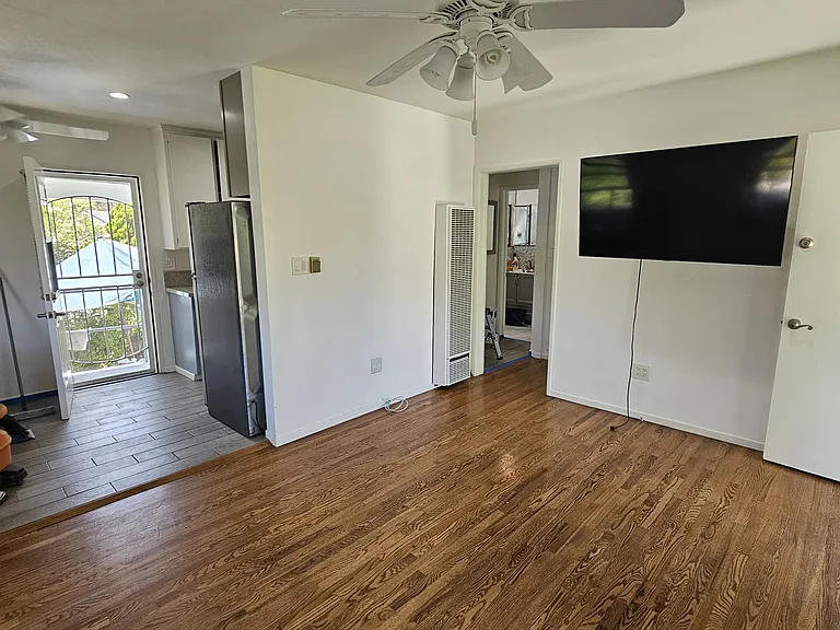 Standing in the corner of front room: Dining area is on the left, showing rear door, and edge of kitchen.