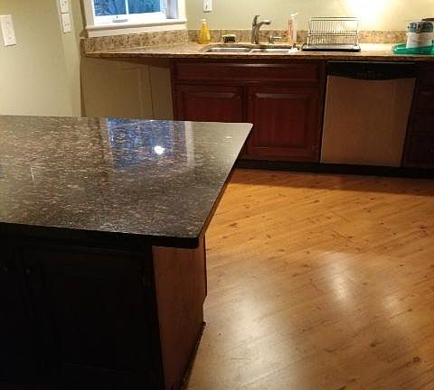 Granite island with additional cabinet storage below.