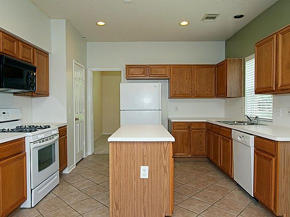 Recessed lighting, built-in microwave and large pantry are features of this kitchen.