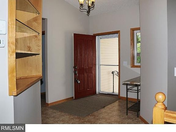 Large vaulted foyer with corner built-in lighted display cabinet and ceramic tile