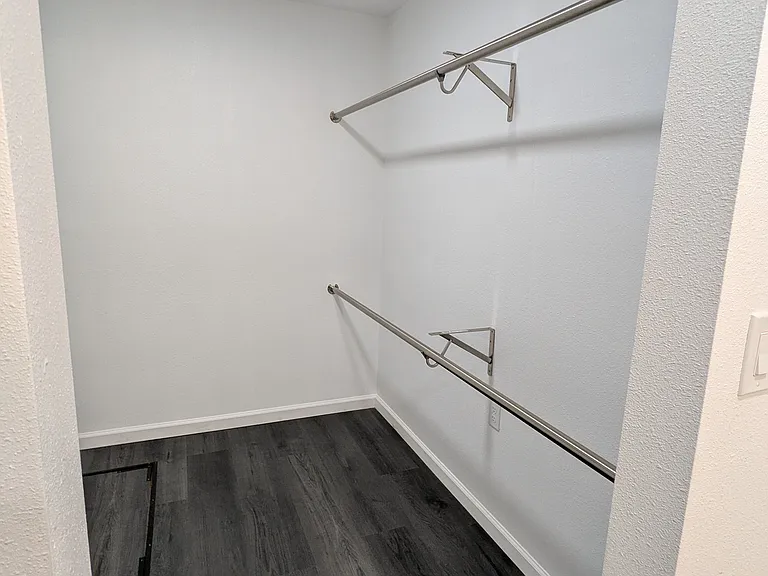Walk in closet has loads of clothes rack space.