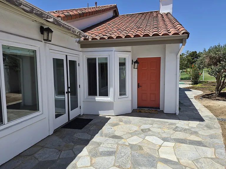 Flagstone patio wraps around home. Beautiful patio areas for enjoying the sun or shade.