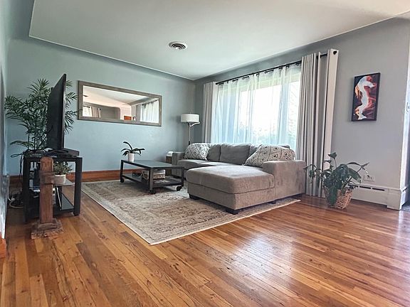 Front living room with huge window and entrance door with rod iron screen/security door.