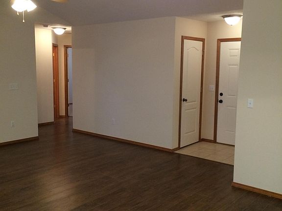 Photo shows Entry door and closet, flooring, and hallway to 2 guest bedrooms and guest bathroom
