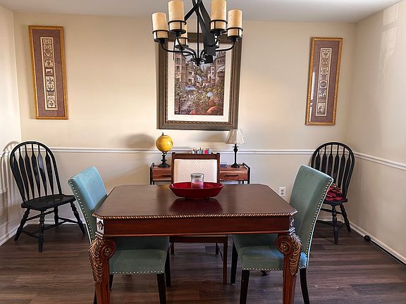 Dining room opens into living room with modern chandelier.