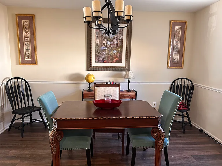 Dining room opens into living room with modern chandelier.