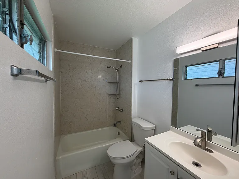Primary bedroom en suite bathroom. Recently updated solid surface bath-surround.