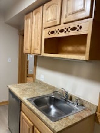 Kitchen sink, granite countertop, wood grain cabinets