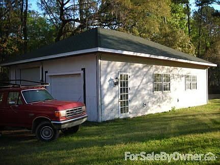 Custom-built garage can accommodate 4 cars, a boat and much more!