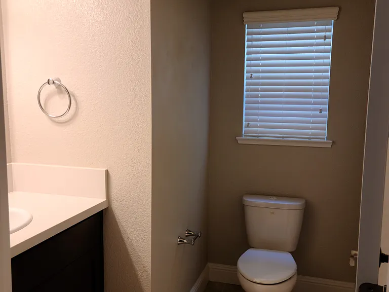 View of the half bath downstairs that is located in the hallway between the living room and dining room.