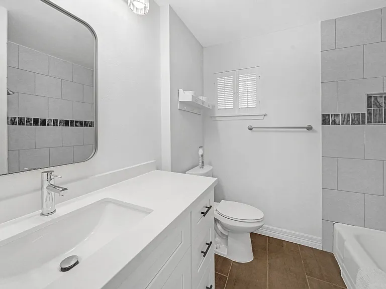 Secondary bathroom with a bathtub and shower in one