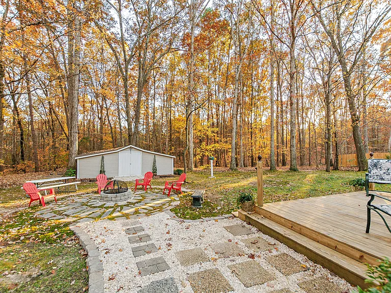 Walkway going down the side of the house toward the fire ring area. Playhouse is off to the left.