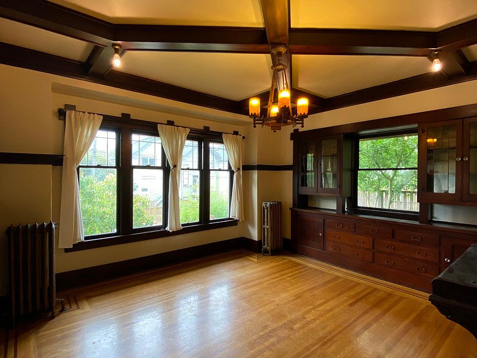 Boxed beam ceiling in dining room with built-in buffet and chandelier