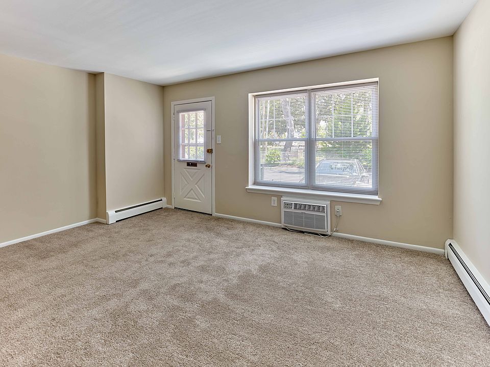 Light-filled living room with plush carpet and oversized window at 42 West Apartments in Merchantville, NJ