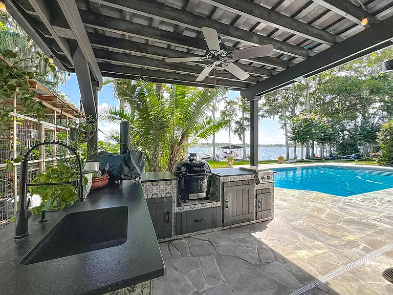 Outdoor Kitchen with sink, fridge, smoker, gas pizza oven and Bar with gas fire pit and TV