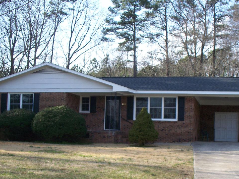 All brick ranch with carport, utility room, large front porch, concrete drive with turn around or extra parking.