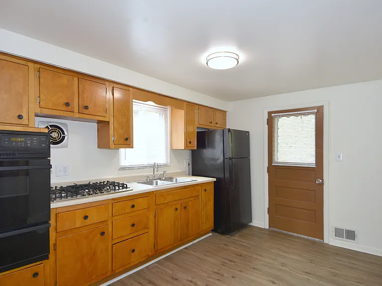 Freshly painted spacious kitchen has room for open shelving & storage, all-new luxury vinyl plank flooring, new gas stove, new faucet, new mini-blinds & LED lighting. Also has access to rear patio.