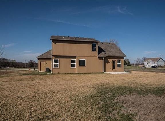 Rear view showing patio and large back yard.  Access to yard from 3 car garage, too!