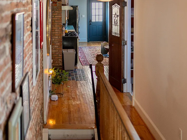 ___ This charming hallway sits between the kitchen and the living area. You can find a unique vintage door that leads to a half bath with a washer dryer.