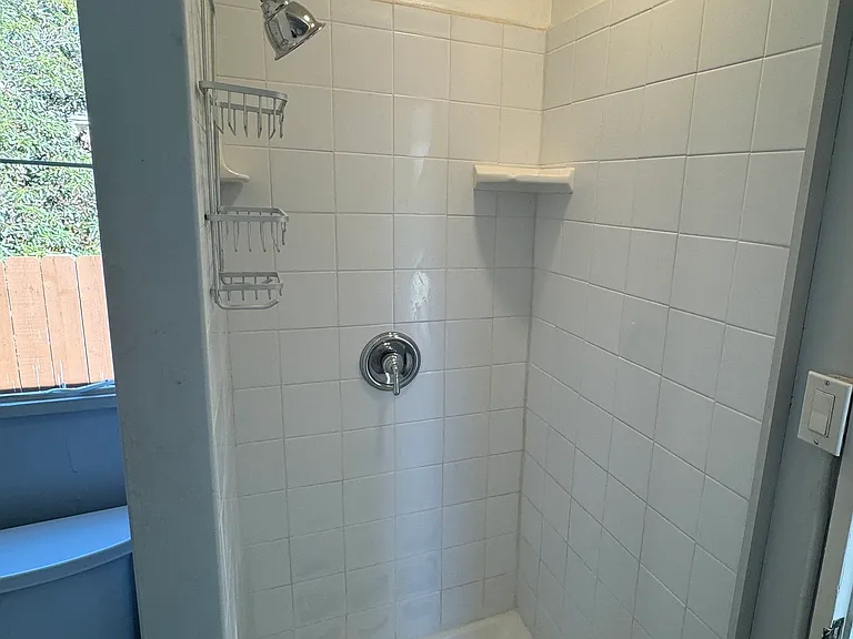 Tiled shower with new LED light and exhaust fan.