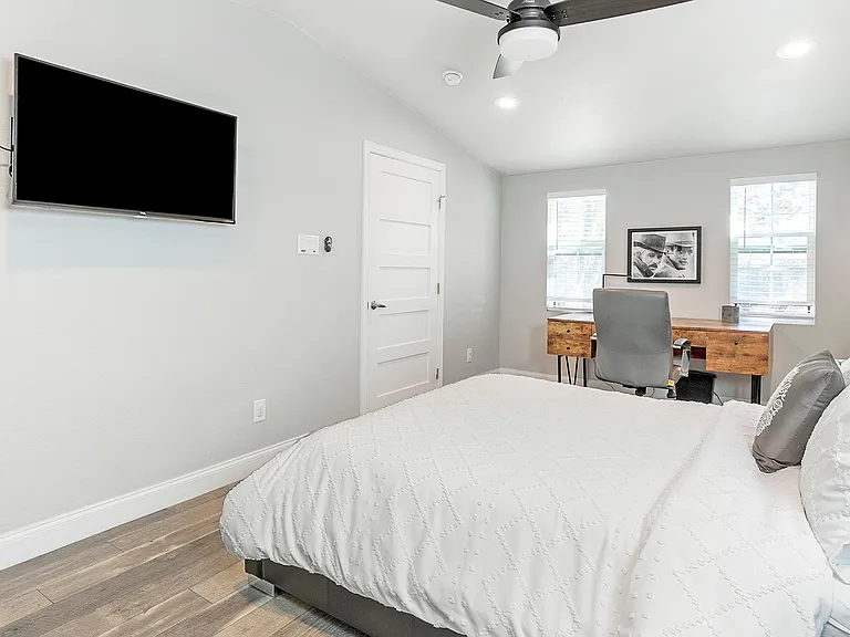 Master bedroom with large-surfaced work desk, 43" Smart TV, and en-suite bathroom