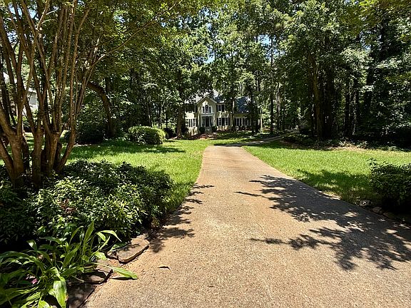 Long private concrete driveway with parking pad