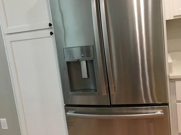 French door refrigerator with drinking water and ice dispensers on the outside of the door. Freezer below
