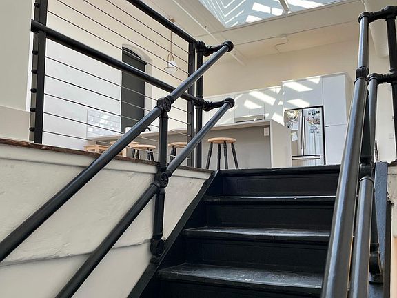 Front door leads to the original steel staircase up to the open loft area.
