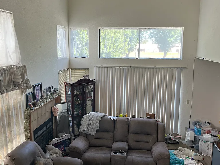 Living room with vaulted ceiling and picture windows, bright and airy, fireplace