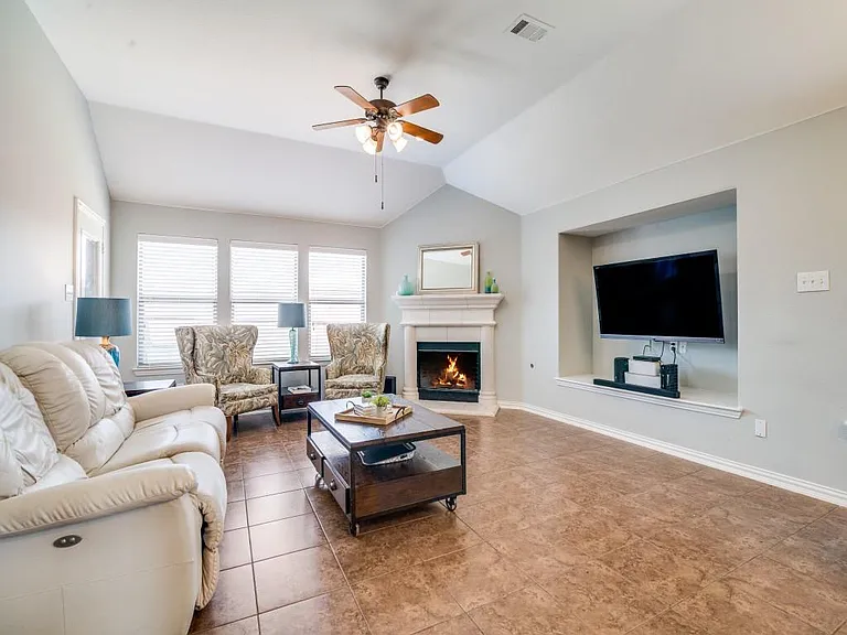 Living room w fireplace, sunlight, open to kitchen.