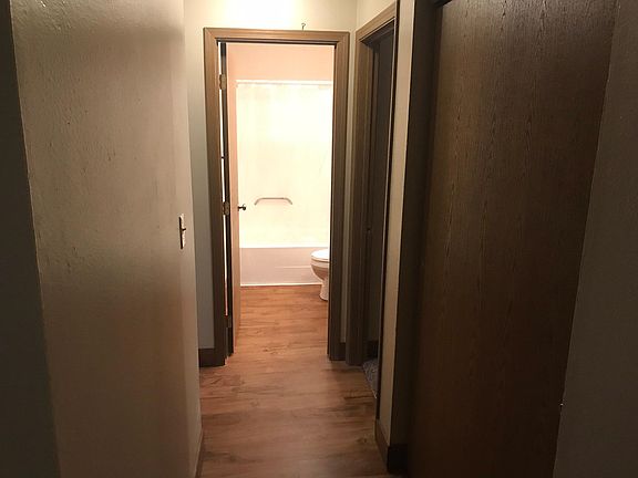 Hallway to bedrooms and bathroom has ample storage in the closet on right