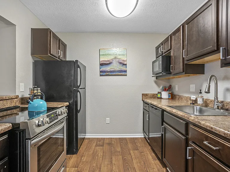 Fully equipped kitchens include modern black appliances.