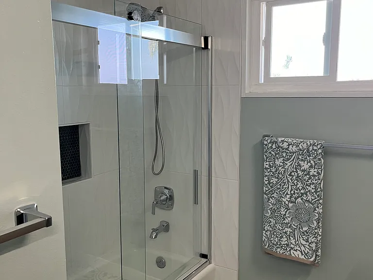 Upstairs bathroom shower tub combo with sliding glass door.
