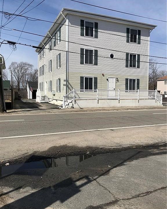 Front of building, south side driveway and garage in rear.