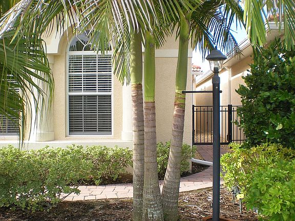 Mature landscaping of palms and flowering shrubs makes an attractive entry!