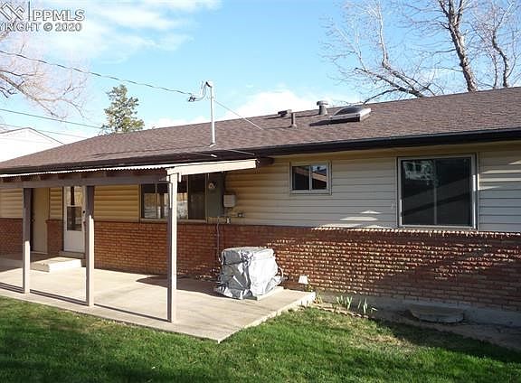 BACK of home, with large 31' X 10' covered patio, upgraded vinyl windows on main level, skylight in main level bath and AIR COND