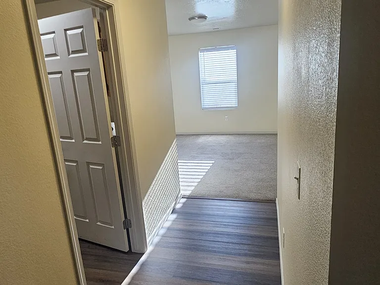 Hallway looking into laundry on the left and extra room to be used as office or play area