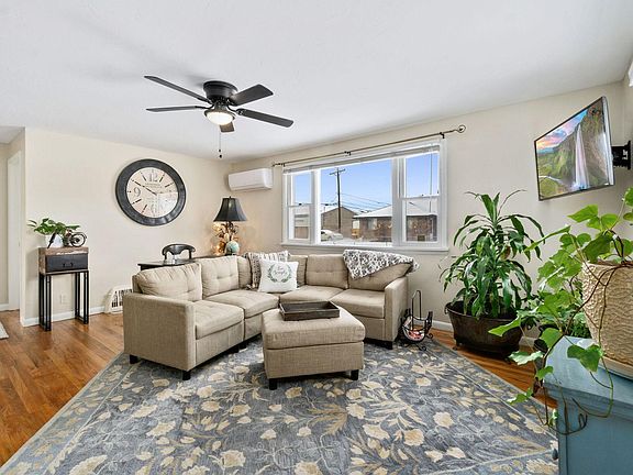 spacious living room with sectional couch, large TV, and desk station for workspace.