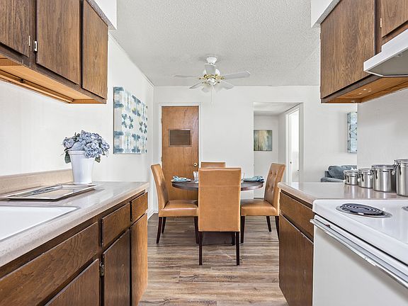 Open Kitchen and Dining Room with Hardwood Floors - Raindance Apartments