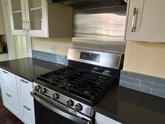 Recently remodeled kitchen with new cabinets, gas stove, backsplash and countertops