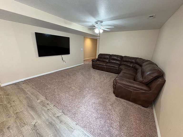 Living room with leather sectional and big screen TV