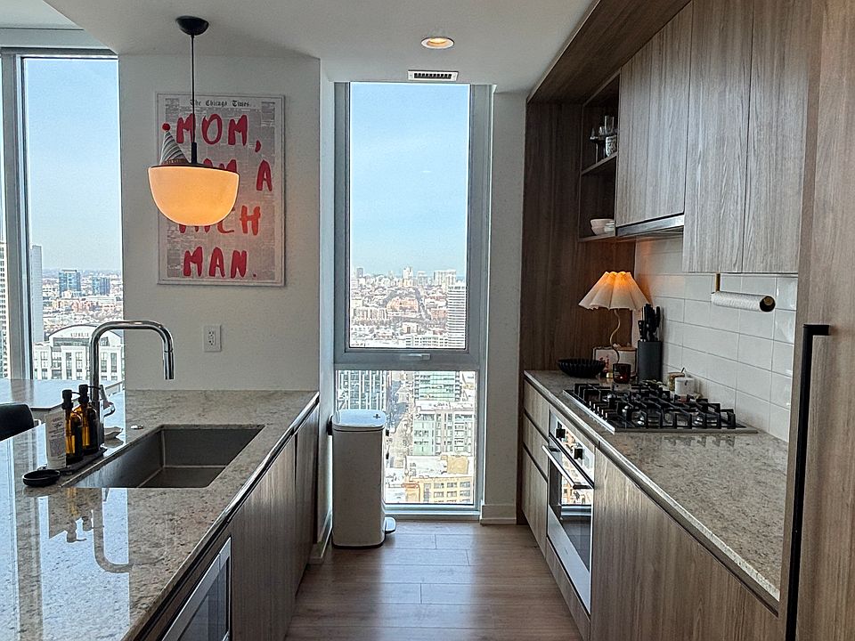 Built-in kitchen appliances with warm, light wood finishes. The kitchen includes a full fridge, freezer, microwave, stove, and oven.