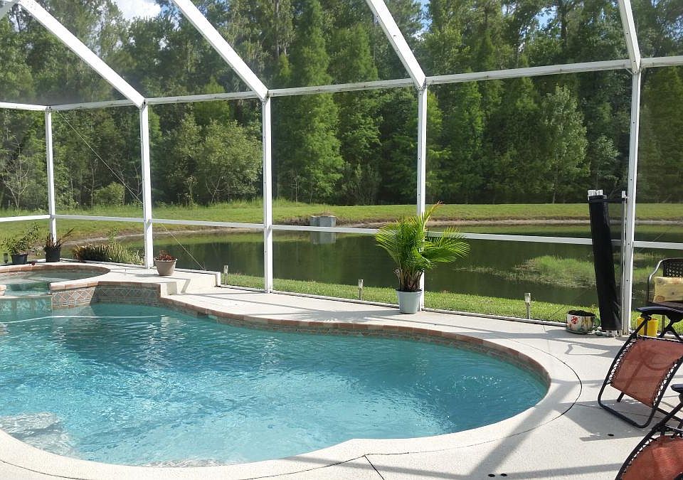Hot tub with waterfall into pool and water views by conservation