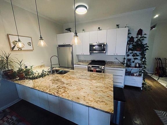Newly renovated kitchen with extra storage space under island with marble counter tops.