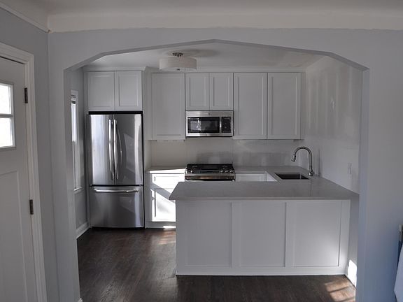 Freshly remodeled kitchen with peninsula with seating for four, new cabinets and quartz countertops, and new appliances including high-end stainless steel gas range, dishwasher and built-in microwave. Subway tile backsplash and under-cabinet lighting.