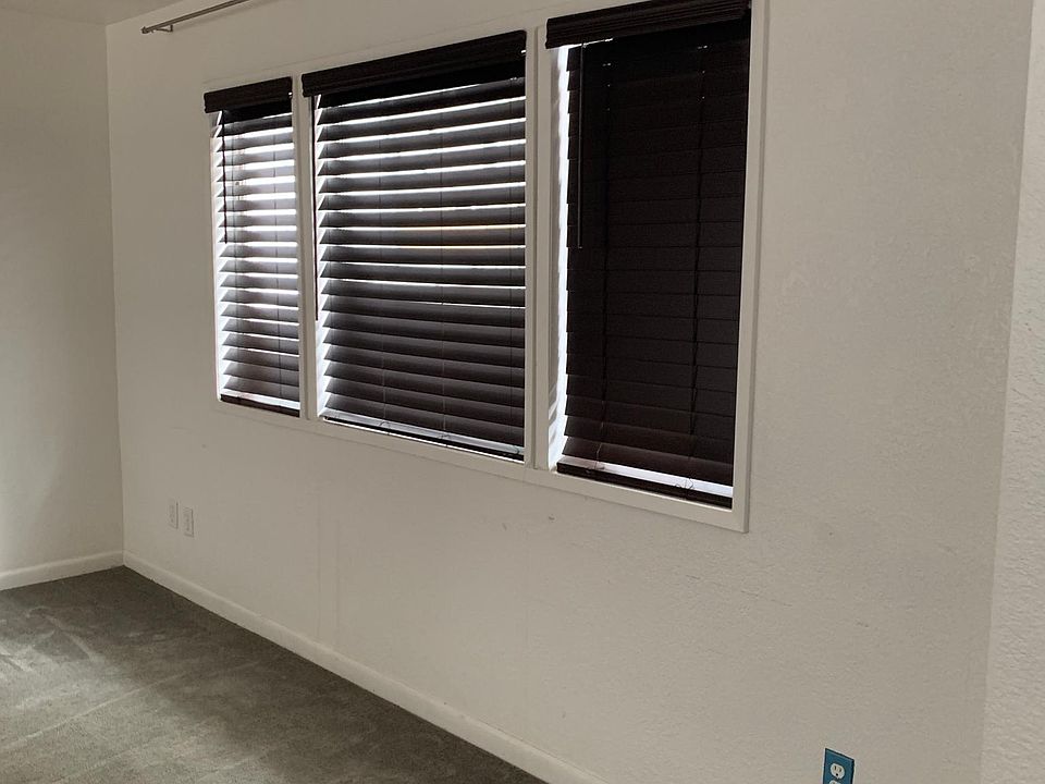 Living room with wood-style shades on 3 windows