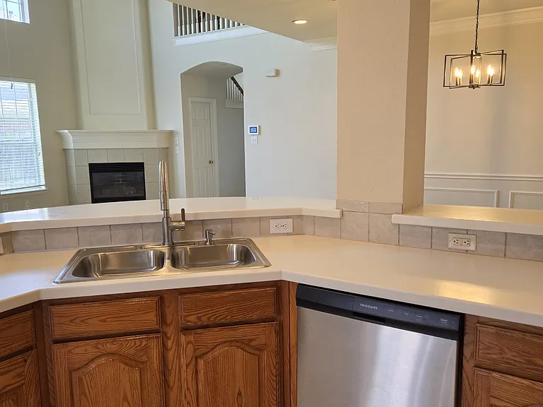kitchen sink, dishwasher looking out to formal dining room to right, living area to left