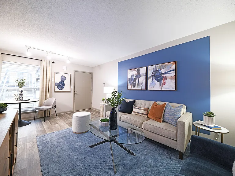 Relax in this stylish living room, featuring a blue accent wall and elegant decor.