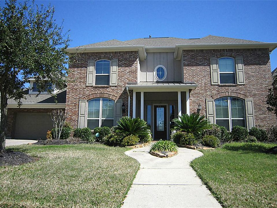 Lovely landscaping highlights the entrance to this 5 bedroom home.